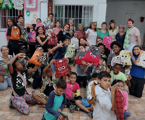 Grupo de crianças e adultos com mochilas artesanais